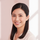 Portrait of a smiling young woman with sleek, styled hair, conveying confidence and satisfaction.